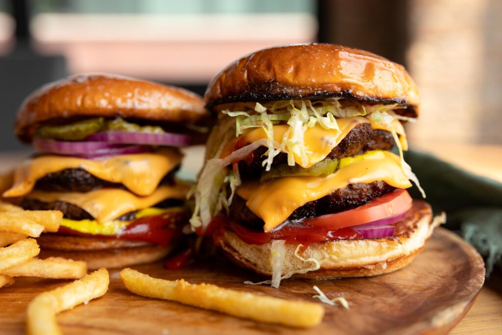 two cheeseburgers with fries on a plate