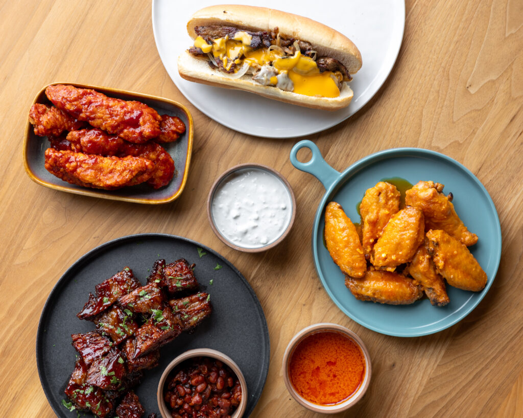 chicken, brisket, and cheesesteak on table