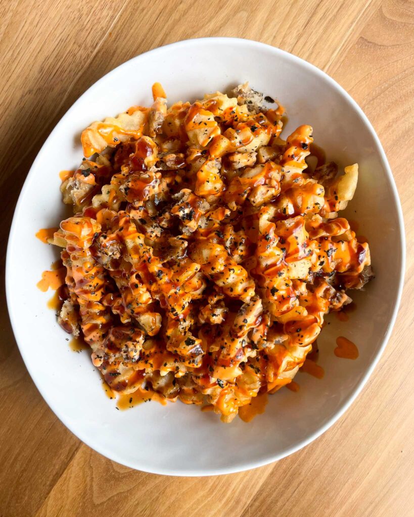 fries with drizzled sauce in a bowl