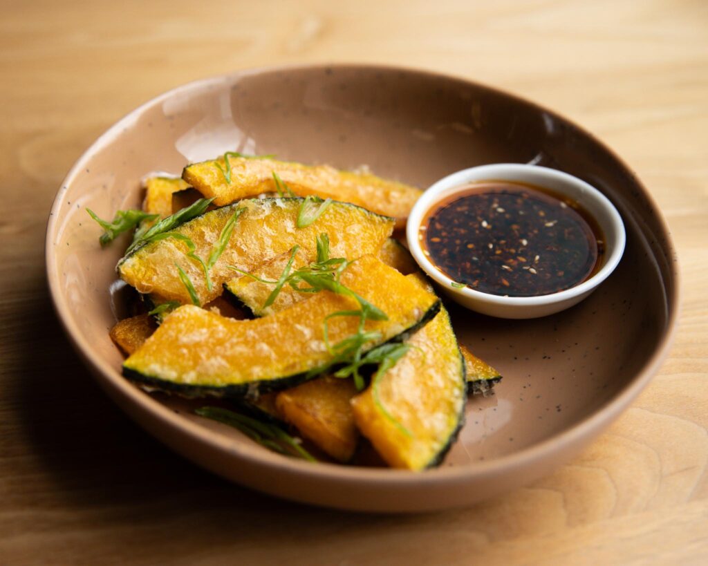 Fried pumpkin slices in bowl with chili crisp